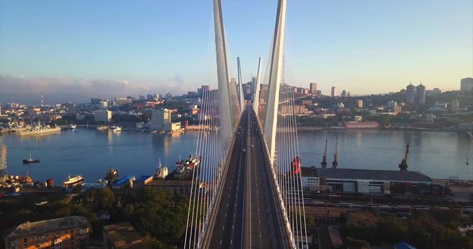 Flying above the road between stay cables of Zolotoy Bridge (Golden Bridge, cable-stayed bridge across Zolotoy Rog harbour built in 2012). Aerial view of cars driving across it. Vladivostok, Russia