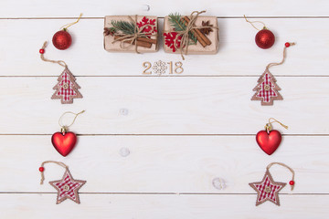 Concept christmas background with decorations, xmas tree and gift boxes on white wooden board. New year card. Empty space for your text. Sigh symbol from number 2018