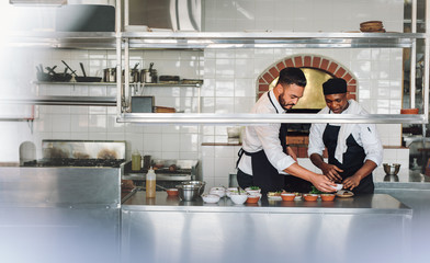 Chefs cooking food at commercial kitchen