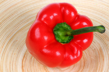 Red bell pepper on wooden plate