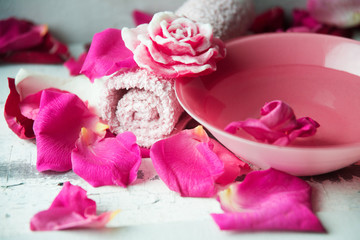 Bowl of aroma spa water with rose petals on towel, closeup