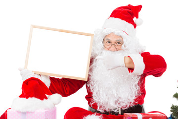 Merry christmas,Santa Claus pointing in white blank sign,Isolated on white background.