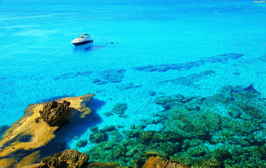 Fototapeta na wymiar Motor yacht parked in beautiful blue bay. Motor boat in the sea near island Cyprus.