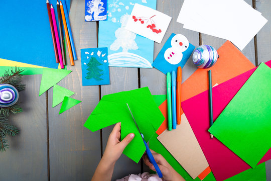 Child hands make handmade christmas toys from cardboard. Children's DIY concept.