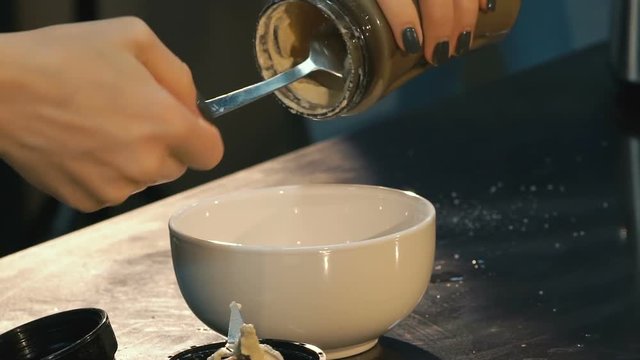 Throwng sause from jar into a bowl