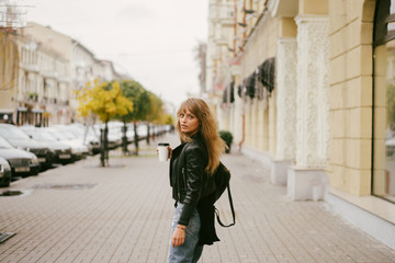 Portrait of a beautiful girl on the street, holding a paper cup