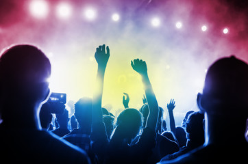Obraz premium Concert Crowd. Silhouettes young people in front of bright stage lights. Band of rock stars