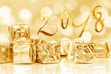 2018, small Christmas gifts in shiny golden paper, bokeh lights background