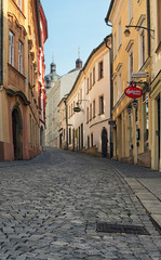 Fototapeta na wymiar OLOMOUC, CZECH REPUBLIC-AUGUST 27, 2017: A narrow and winding street in the old town of Olomouc. Czech Republic. Summer morning view