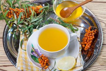Tea made from sea buckthorn berries healthy for health delicious, saturated with vitamins surrounded by berries and sea buckthorn leaves for family tea drinking and maintaining health in the body