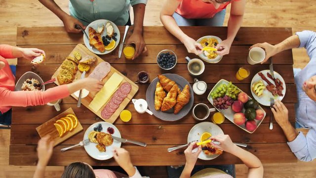 group of people eating at table with food