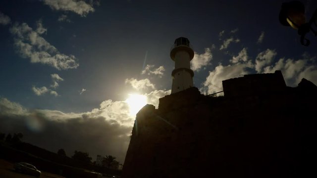 lighthouse on the wall of the fortress of Famagusta and the evening sun near closed ghost town Varosha in North Cyprus