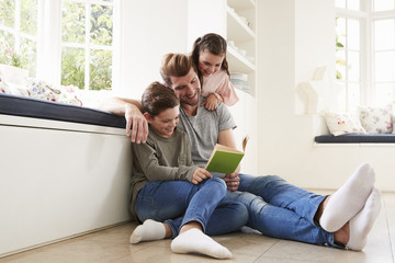 Father Reading Book With Son And Daughter At Home