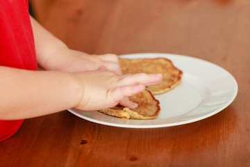 Obraz na płótnie Canvas Little boy preparing pancakes for breaktfast