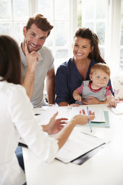 Family With Baby Meeting Financial Advisor At Home