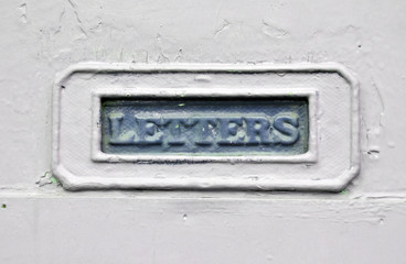 old blue metal letterbox on a painted house door
