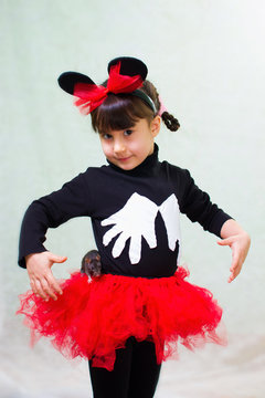 cute little girl in a bear costume with ears holds a hand rat
