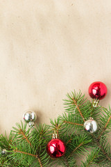 Festive christmas border with red and silver balls on fir branches and snowflakes on rustic beige background