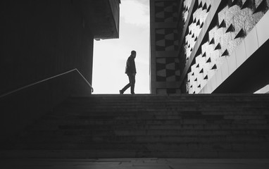 silhouette of a walking man in a city. black and white photo - Powered by Adobe