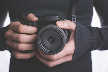 Young man holding camera and lens in hand