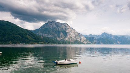 mount Traunstein and lake Traunsee with sailing boat and dramatic sky