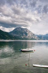 Fototapeta na wymiar mount Traunstein and lake Traunsee with sailing boat and dramatic sky