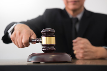 Male Judge lawyer In A Courtroom Striking The Gavel on sounding block in his office