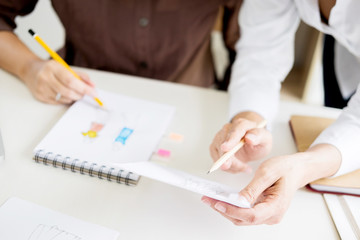 two young men working as fashion designers and drawing sketches and gets fabric advice at a custom tailor.