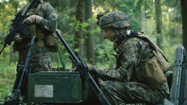 Military Staging Base, Chief Army Engineer Sitting on the Boxes of Ammunition Uses Army Grade Laptop Issued by Military Industrial Complex