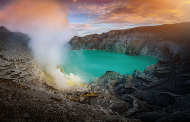 Kawah Ijen volcano with green lake on blue sky background at morning in East Java, Indonesia.
