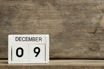 White block calendar present date 9 and month December on wood background