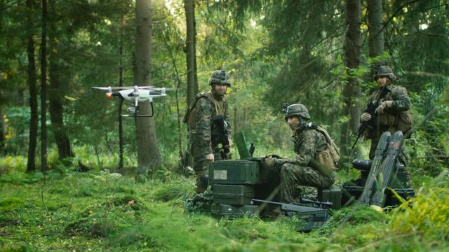 In the Military Staging Base Army Engineer and Soldiers Fly Military Grade Industrial Drone for their Reconnaisance/ Surveillance Mission/ Operation. Theater of Operation is in Forest Area. 