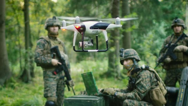 In the Military Staging Base Army Engineer and Soldiers Fly Military Grade Industrial Drone for their Reconnaisance/ Surveillance Mission/ Operation. Theater of Operation is in Forest Area. 