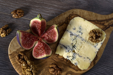 Cheese roquefort with figs and nuts  on a wooden background