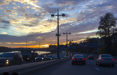 ars traffic in a city  on a sunset background with cumulus clouds. White nights, St. Petersburg, Russia.