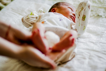 Fototapeta na wymiar Small legs of a newborn baby