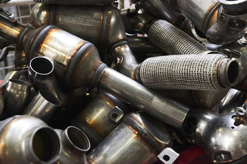 Industrial background. Stacks of new exhausts and silencers mufflers car before distribution and...
