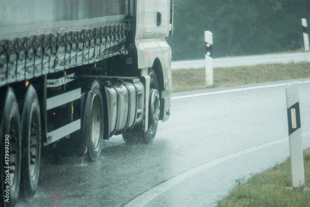 Wall mural a truck is driving on the road in the rain