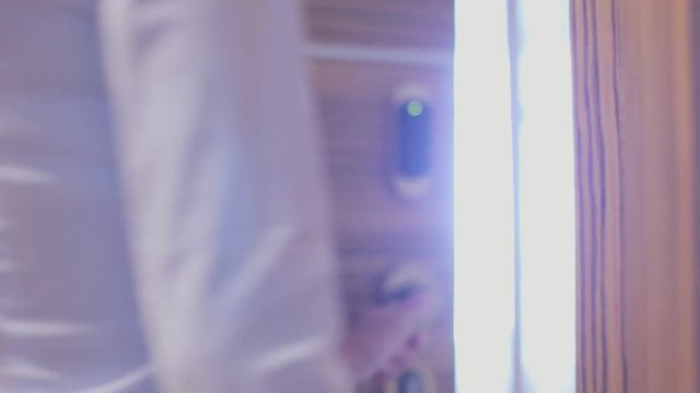 A young woman opens the door of his hotel room using an electronic key card