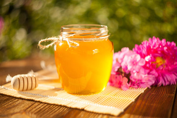 Delicious delicious honey in  jar on table