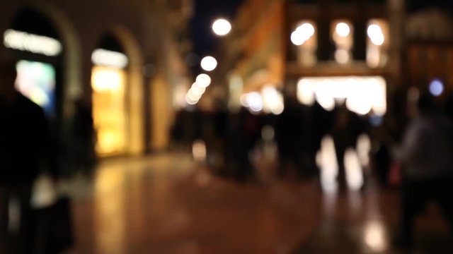 People walking in city night background. Out of focus abstract background