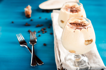 luxurious dessert Tiramisu in a glass on a blue background