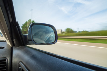 Fototapeta na wymiar Rear view mirror of a car driving on a mountain road. 