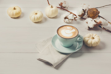 Pumpkin spice latte. Coffee cup on white wood background