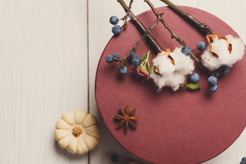 Autumn dried flowers composition with present box on white wood