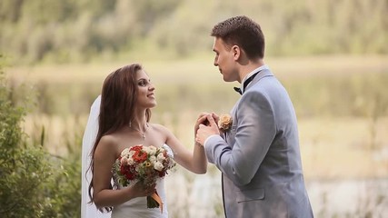 The bride and groom dance outdoors in a park near the lake. Happy together. Wedding day.