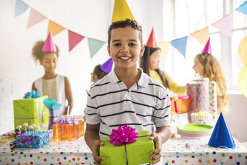 Group of adorable kids having fun at birthday party. African child on the front