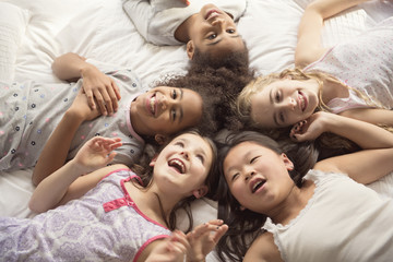 large group of her friends taking goog time on bed