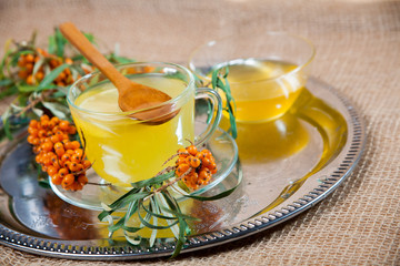 Tea made from sea buckthorn berries healthy for health delicious, saturated with vitamins surrounded by berries and sea buckthorn leaves for family tea drinking and maintaining health in the body