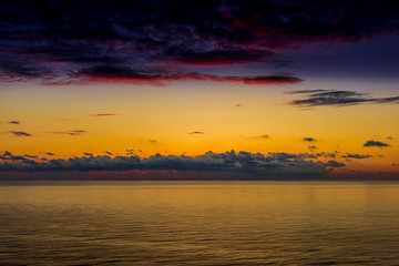 Obraz premium Stylized abstract landscape seascape sunset long exposure with clouds under different shades of blue, orange, yellow and red.